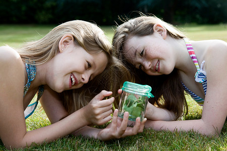 两个女孩看着有昆虫的罐子女人高清图片素材