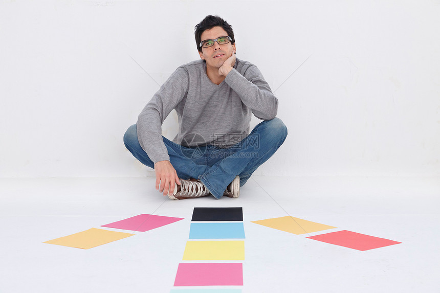男人坐在彩色纸上图片