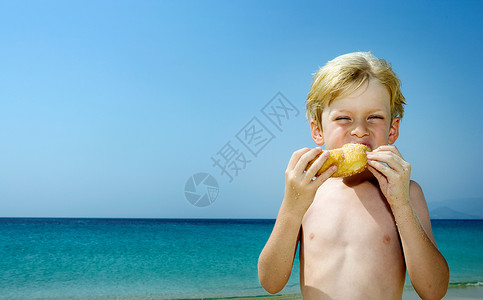 甜甜圈男孩小男孩在海滩上吃甜甜圈背景