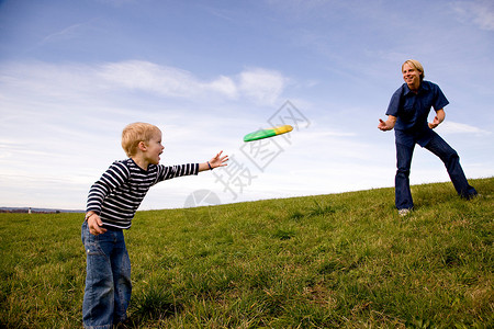 男孩和父亲玩飞盘背景图片
