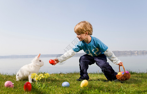 孩子带着小兔子找复活节彩蛋图片素材