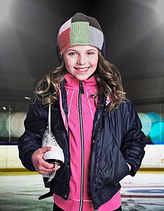 在溜冰场上拿着溜冰鞋的微笑女孩图片
