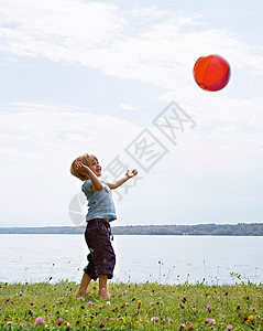 在湖边玩球的男孩阳光高清图片素材