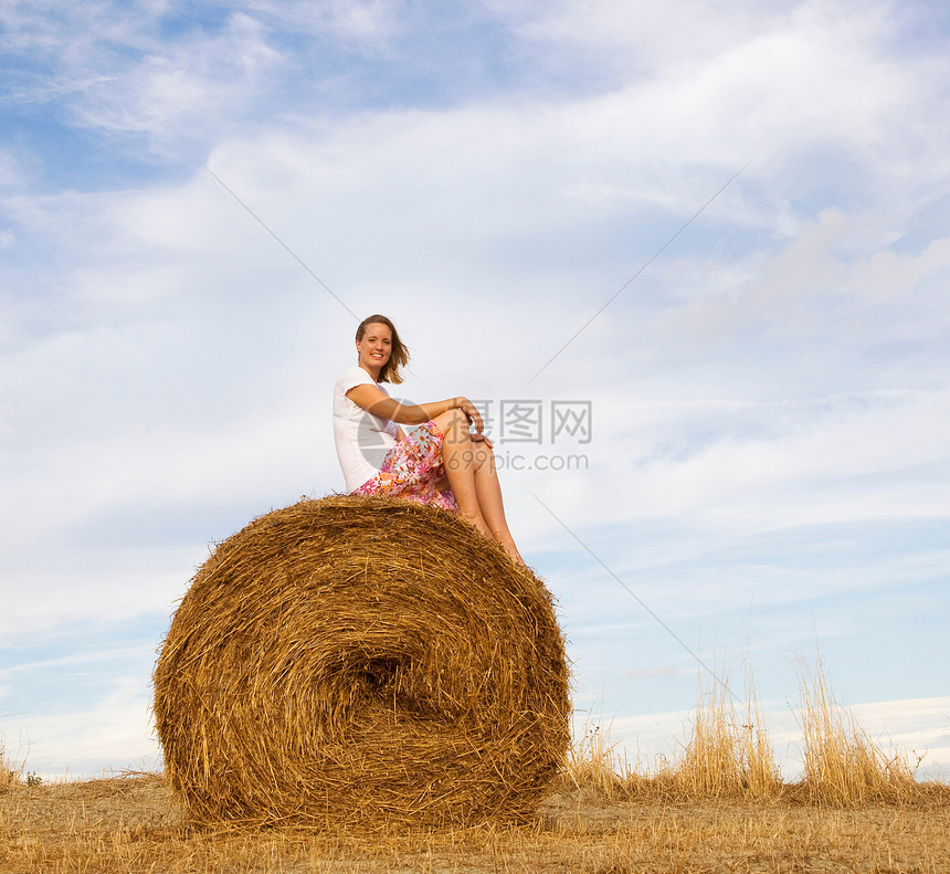 坐在干草捆上的女人图片