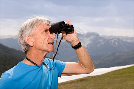 山上带双筒望远镜的老人男人高清图片素材