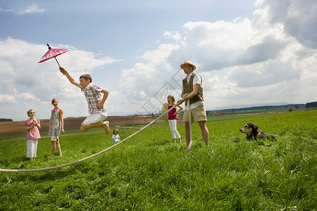 一群狗快乐的人们在农村跳绳背景