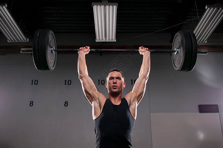 举重健身的男人在健身房举重背景