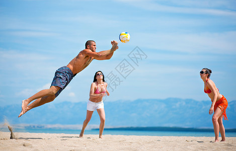 朋友们在沙滩上打排球高清图片