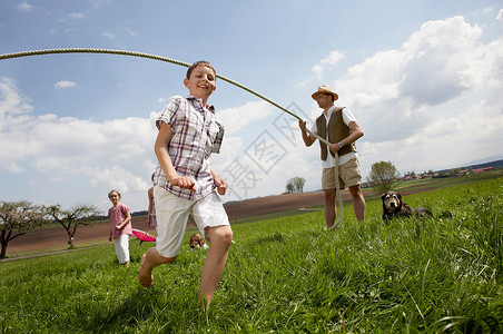 玩跳绳女孩欢乐家庭在农村跳绳背景