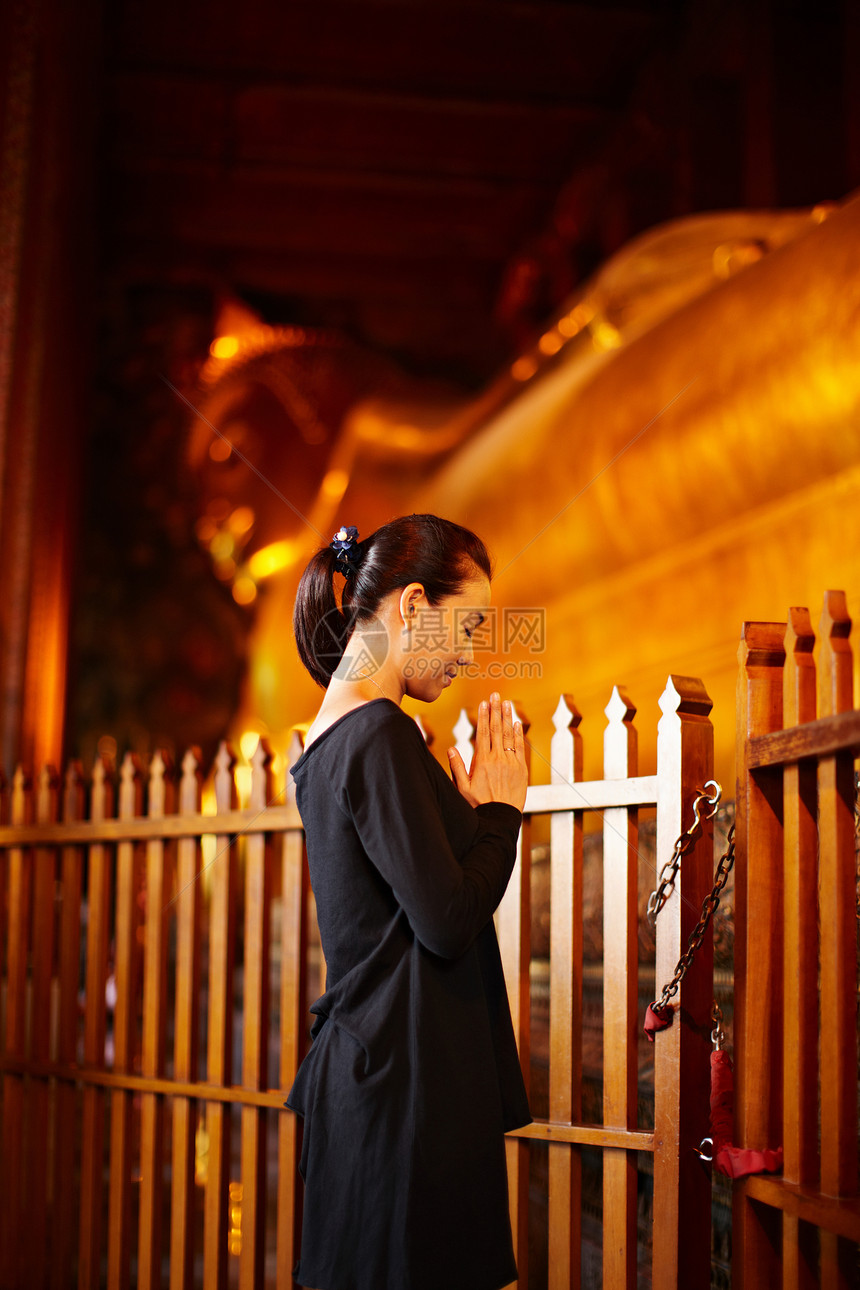 妇女在户外纪念碑祈祷图片