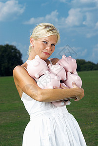 拿着小猪存钱罐的女人图片