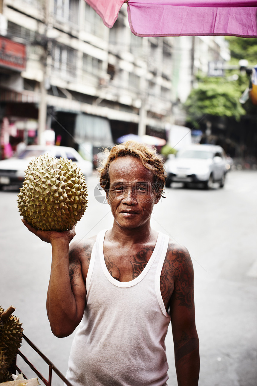 在街头卖榴莲果的人图片