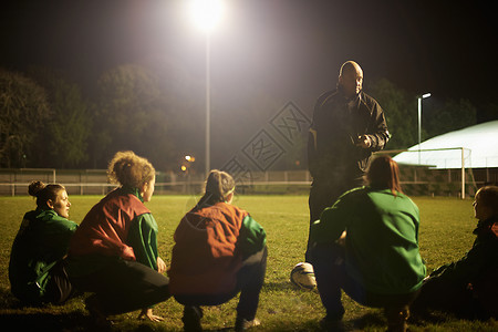 教练在球场上向足球运动员作简报图片