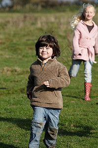 在田里奔跑的男孩和女孩阳光高清图片素材