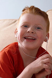 在沙发上戴耳机的男孩图片