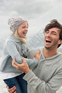 爸爸和女儿在海滩上欢笑图片