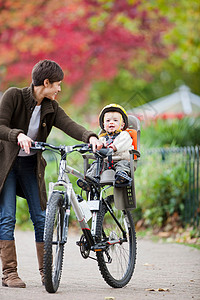 在公园骑自行车的妇女和儿童图片