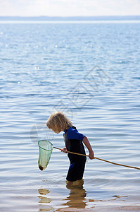 背着渔网的男孩男孩看渔网背景