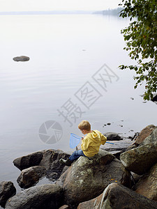 用网在湖里钓鱼的小男孩图片