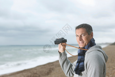 海滩上带着望远镜的男人图片