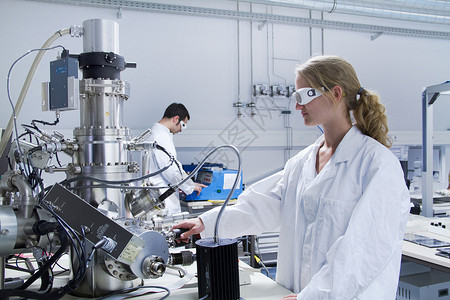 两名科学家穿着实验室外套使用科学设备忙碌高清图片素材