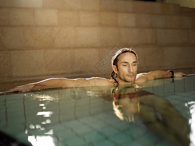 坐在游泳池里的成熟男人背景图片