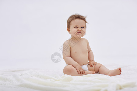 3岁宝宝外国宝宝坐在床上微笑背景