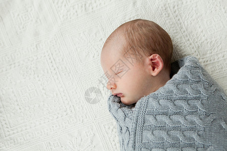 婴儿风包素材婴儿睡在毯子里背景