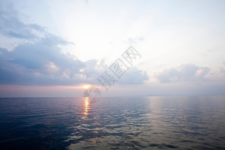 太阳从静止的水面升起背景图片