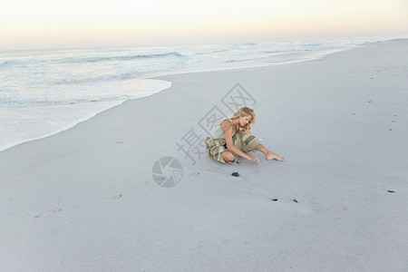 在沙地上画画的女孩图片