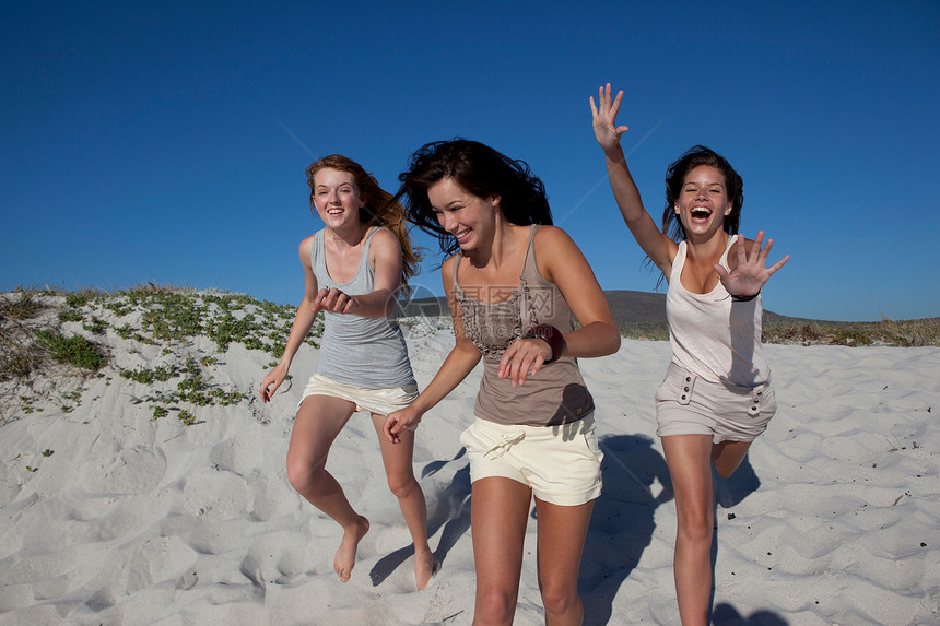 三个女孩海滩奔跑图片