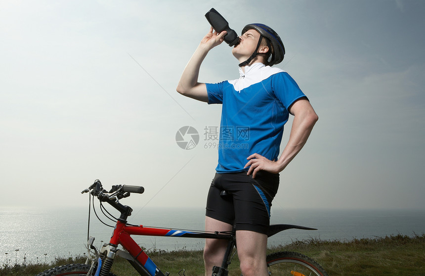 一个骑自行车的男人喝水图片