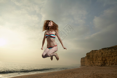 海滩上女子跳跃高清图片