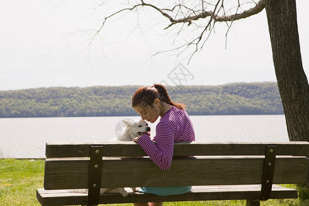 公园长椅上养狗的女人高清图片