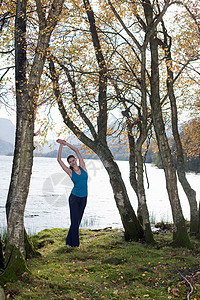 在树间练习瑜伽姿势的女人图片