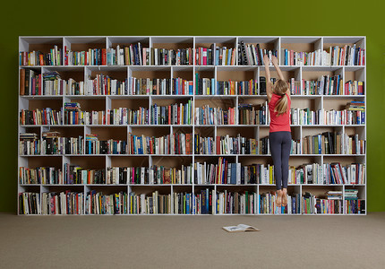 女孩跳到书架上找书背景图片
