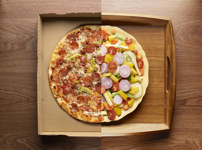 一半披萨，一半蔬菜放在盘子里，俯视图背景图片