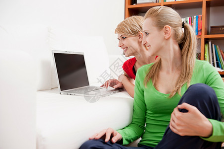 在沙发上使用笔记本电脑的女性金色头发高清图片素材