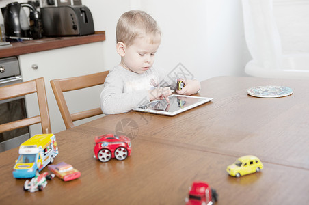小孩玩具车使用数字平板电脑的男孩背景