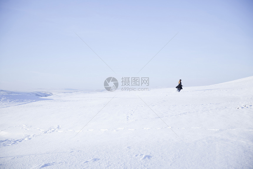 在雪景中行走的年轻女孩图片