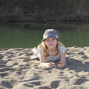 小女孩躺在沙滩上图片