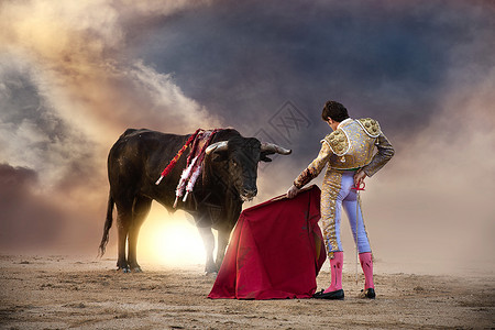 斗牛士手持红斗篷和公牛背景图片