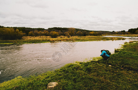 年轻女子蹲在河边图片