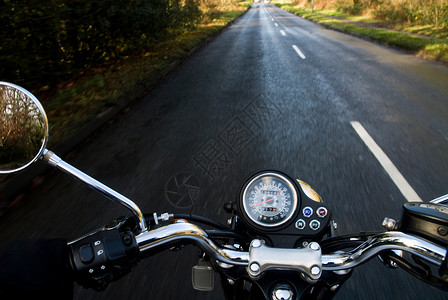 视点拍摄空旷乡村道路上的摩托车背景