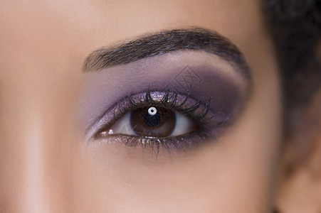 紫色眼睛美丽少女的极端特写镜头背景
