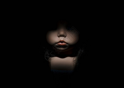 黑暗中娃娃的脸背景图片