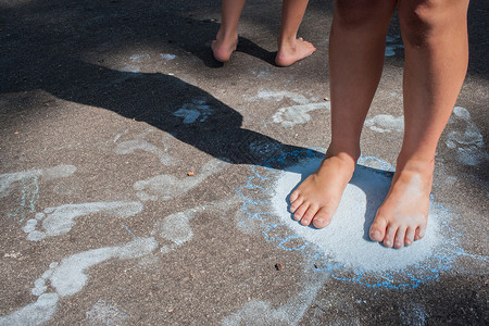 修女赤脚在人行道上踩粉笔脚印图片