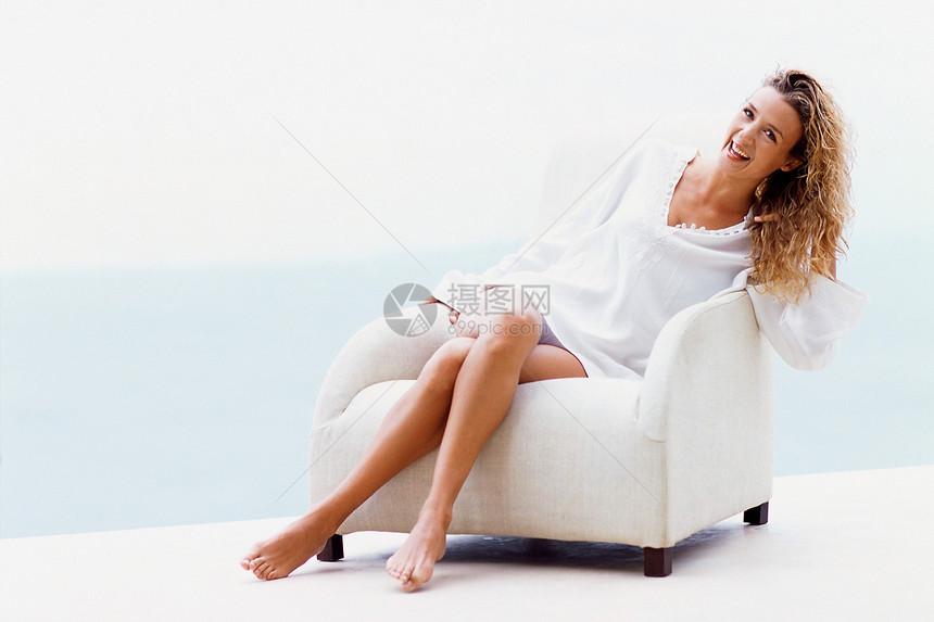 坐在白色扶手椅上的女人图片