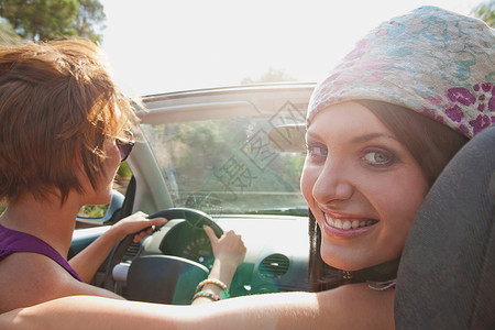 阳光下两个女人坐敞篷车里图片