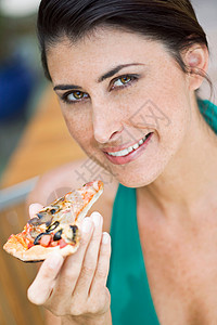 一个女人拿着一块披萨特写镜头高清图片素材